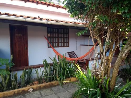 a house with a hammock in front of it at Pousada Barcarola in Búzios