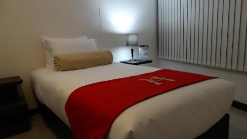 a hotel room with a bed with a red shirt on it at HOTEL OLIMPIA in Duitama