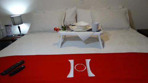 a white bed with a red and white table on it at HOTEL OLIMPIA in Duitama