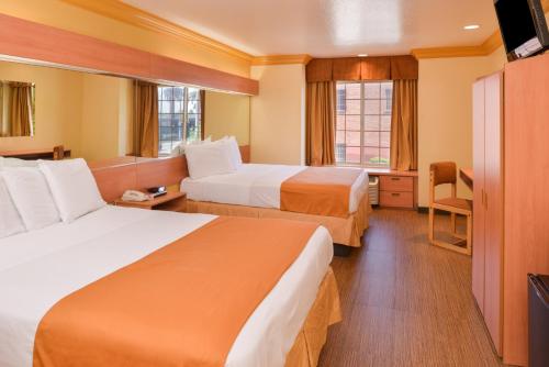a hotel room with two beds and a television at H3 Inn & Suites - LAX Airport - Los Angeles in Inglewood