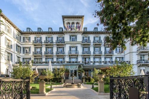 duży biały budynek z wieżą zegarową na górze w obiekcie Grand Hotel du Lac - Relais & Châteaux w mieście Vevey