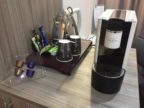 a coffee maker and a laptop on a desk at Hôtel Saphir Lyon in Lyon