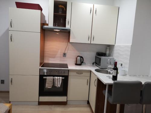 a kitchen with white cabinets and a stove top oven at Lubawskie Zacisze in Lubawka