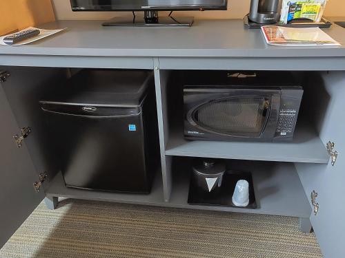 a desk with a microwave and a computer on it at Country Inn & Suites by Radisson, Seattle-Tacoma International Airport, WA in SeaTac