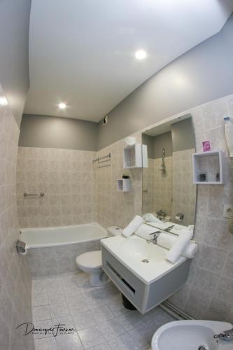 a bathroom with a sink and a toilet and a tub at hotel des 2 nations in Luchon