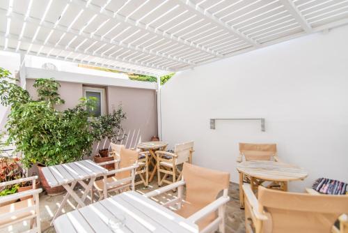 un patio con mesas y sillas en un edificio en Flora, en Tinos