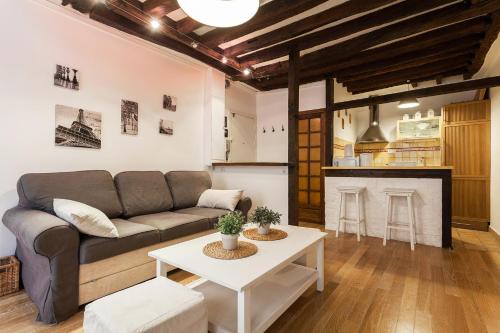 uma sala de estar com um sofá e uma mesa em Apartment Saint Jacques Notre Dame de Paris em Paris