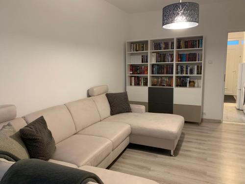 a living room with a couch and a book shelf at ORIGO in Győr