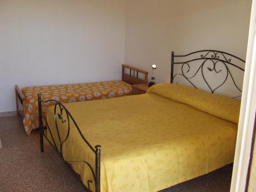 um quarto com 2 camas com lençóis amarelos em Casa vacanza Casalabate em Casalabate