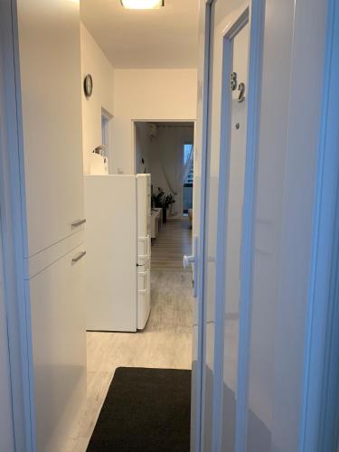 a kitchen with a white refrigerator and a hallway at ORIGO in Győr