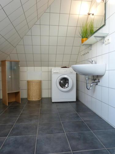 a bathroom with a washing machine and a sink at Ferienwohnung Sommerwind in Klütz