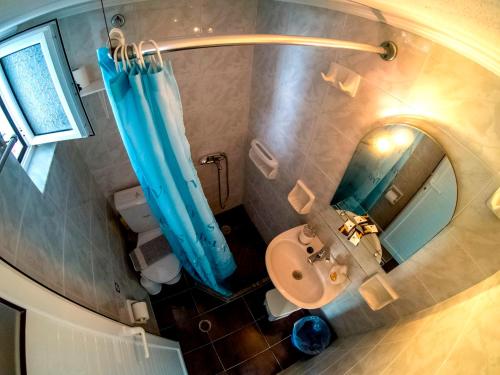 an overhead view of a bathroom with a blue shower curtain at The Captain in Elafonisos