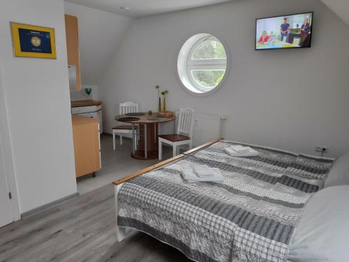 a bedroom with a bed and a table and a window at U Marka in Dąbrowy