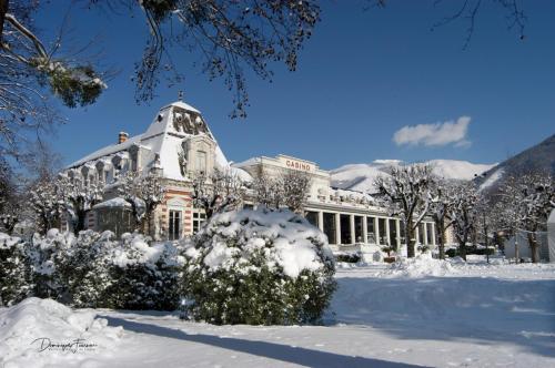 a building covered in snow with snow covered trees at hotel des 2 nations in Luchon