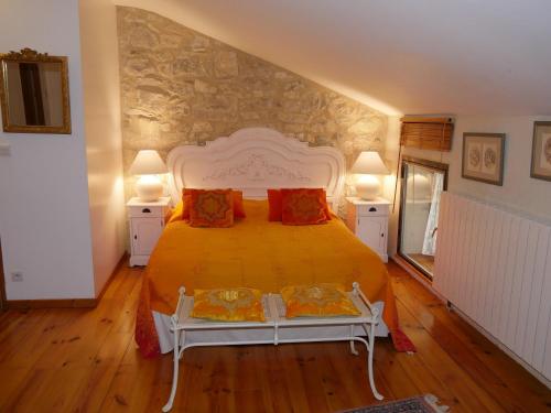 Saint-ThoméにあるLe Moulinageのベッドルーム1室(大型ベッド1台、ランプ2つ付)