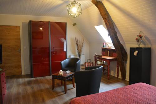 a living room with a red door and a table and chairs at La bergerie de Laura in Vaillac