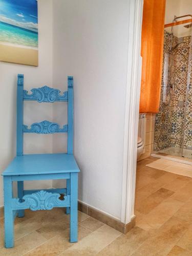 a blue chair sitting in a bathroom next to a shower at BnB Le Janas in Càbras