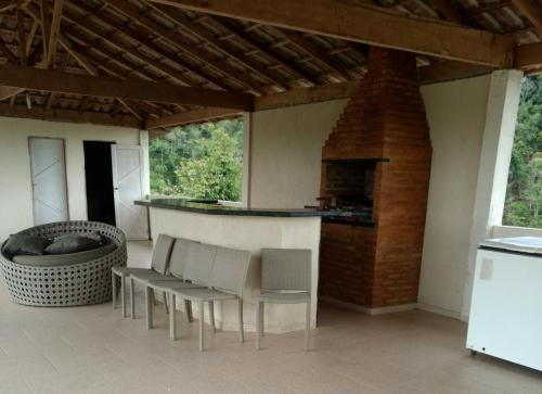 eine Terrasse mit einer Bar, Stühlen und einem Kamin in der Unterkunft Casas Regiao de Pedra Azul Cverde in Domingos Martins