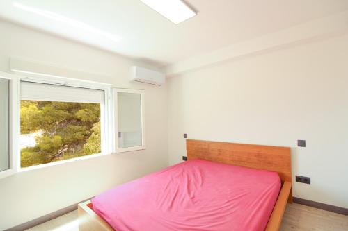 1 dormitorio con cama rosa y ventana en MAR23J, en La Canuta