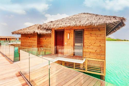 a small hut on the water with a deck at Royalton Antigua, An Autograph Collection All-Inclusive Resort in Five Islands Village