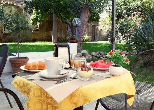 a table with a yellow table cloth with food on it at Cosmo Rooms a pochi passi da Tropea in Tropea