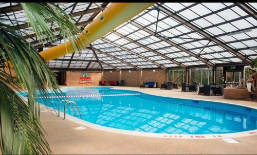 een groot zwembad met een glazen plafond bij H&B Caravan on Marine Holiday Park in Rhyl