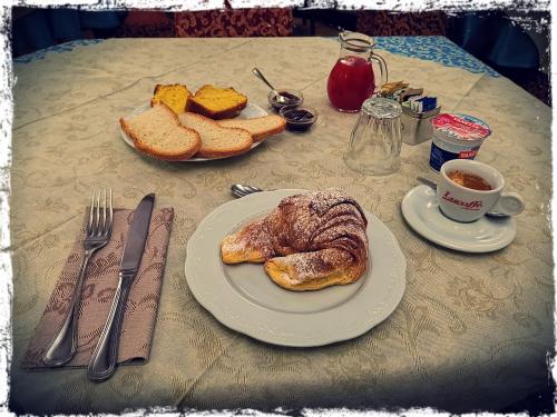 een tafel met een bord brood en een kopje koffie bij Montelupone Bed & Breakfast in Montelupone