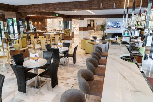 restauracja ze stołami i krzesłami oraz bar w obiekcie Poseidon Hotel w mieście Kamínia