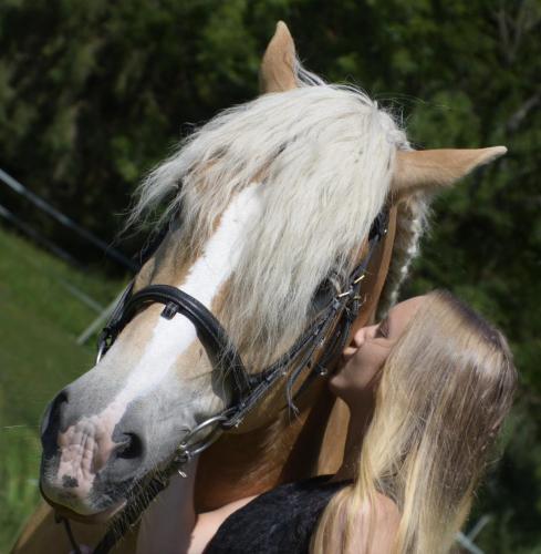 a woman standing next to a brown and white horse at Knaller der Reiterbauernhof in Reisach