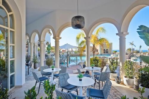 een patio met tafels en stoelen en uitzicht op het water bij The Level at Meliá Villaitana in Benidorm