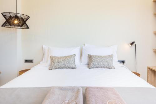 a bedroom with a white bed with two pillows at 180 South Seaside Hotel in Thermisia