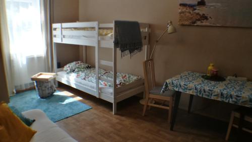 Cette petite chambre comprend 2 lits superposés et une table. dans l'établissement Chojnice - mieszkanie w kamienicy, à Chojnice