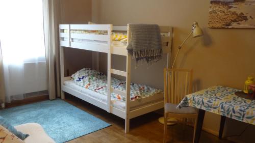 ein Kinderschlafzimmer mit 2 Etagenbetten und einem Tisch in der Unterkunft Chojnice - mieszkanie w kamienicy in Chojnice