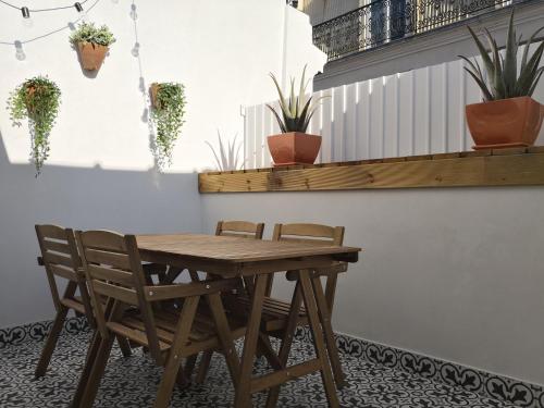 a wooden table and chairs in a room with plants at BairroSweethome in Lisbon