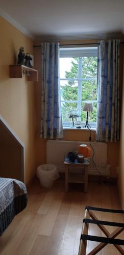 a bedroom with a bed and a window and a table at Skutskepparn Kuststation in Nordingrå