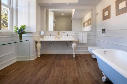 a bathroom with two sinks and a tub and a mirror at Hotel Casa Palmela - Small Luxury Hotels of The World, Hotel & Villas in Setúbal