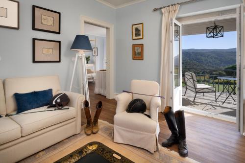 a living room with a couch and chairs and a balcony at Hotel Casa Palmela - Small Luxury Hotels of The World, Hotel & Villas in Setúbal