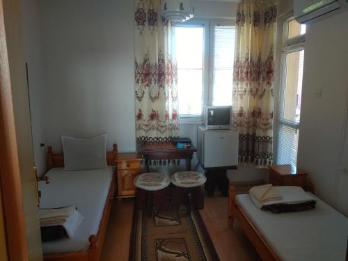 a small room with two beds and a window at house georgievi in Sozopol