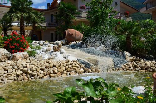 a water feature in a yard with a fountain at Hotel La Grotte in San Donato Val di Comino
