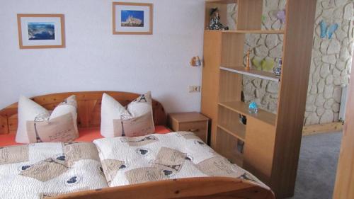 um quarto com uma cama com lençóis brancos e almofadas em Feriendomiziel Läsker em Mittelndorf