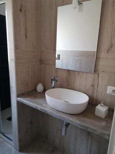 a bathroom with a white sink and a mirror at Domo Green House in Villasimius