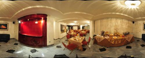 Hotel Cordero في كوينكا: غرفة بها مجموعة من الطاولات والكراسي