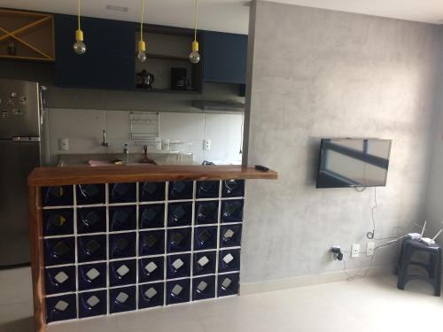 a kitchen with a bunch of wine bottles on the wall at Conforto - VOG Torres do Sul Ilhéus in Ilhéus