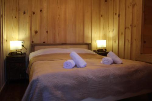 a bedroom with a bed with two towels on it at Ecohouse Svaneti in Mestia