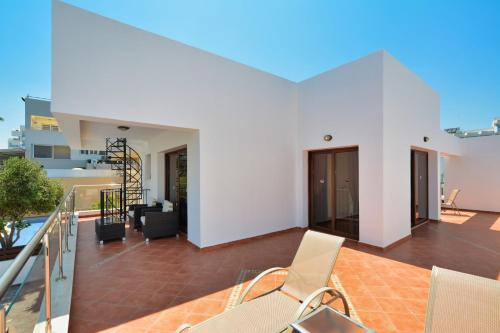 a balcony with white walls and chairs on a building at Seafront Protaras Villas in Protaras
