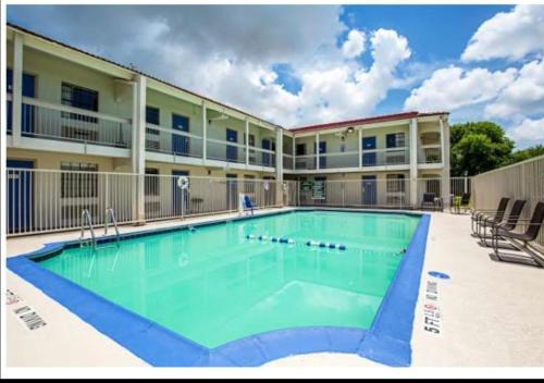 una gran piscina frente a un edificio en Scottish Inns & Suites, en Texas City