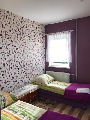 a bedroom with two twin beds and a window at Restauracja Łania in Koszalin