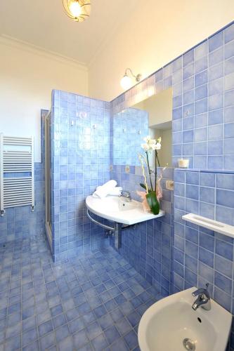 a blue tiled bathroom with a sink and a mirror at Residenza Villa Titina in SantʼAgata sui Due Golfi