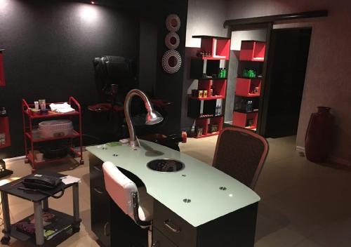 a hair salon with a sink and a mirror at The Royal Courtyard in Matatiele