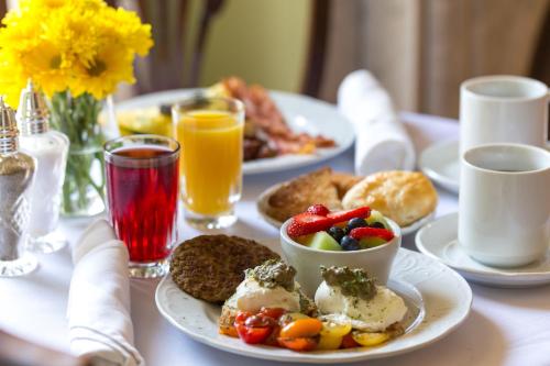 a table topped with plates of breakfast foods and drinks at The Gastonian, Historic Inns of Savannah Collection in Savannah